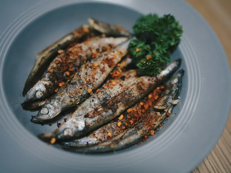 Mokli sardines grillées : Le mokli — sauce tomate fraîche, poivron vert frit, œuf au plat, frites maison —, avec des sardines grillées